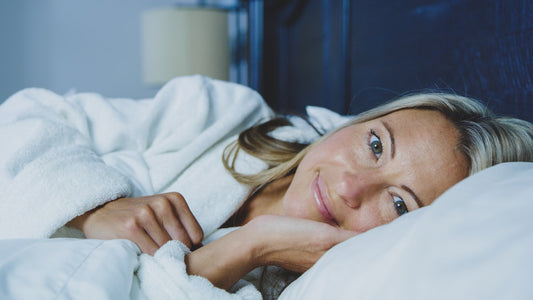 A woman resting calmly in bed in soft morning light