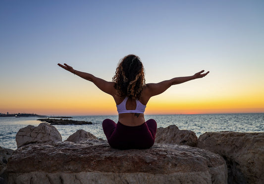 Woman sitting by the ocean - understanding PMS hormonal causes