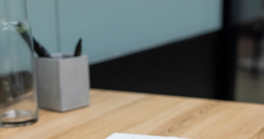 An open notebook and pen on a wooden desk in a quiet consulting room