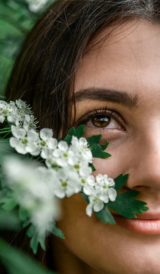 Woman with white flowers on her face - the follicular phase and skin health