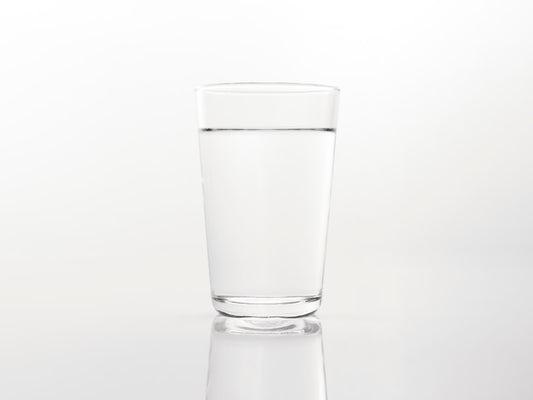 Glass of water on a reflective surface representing hydration